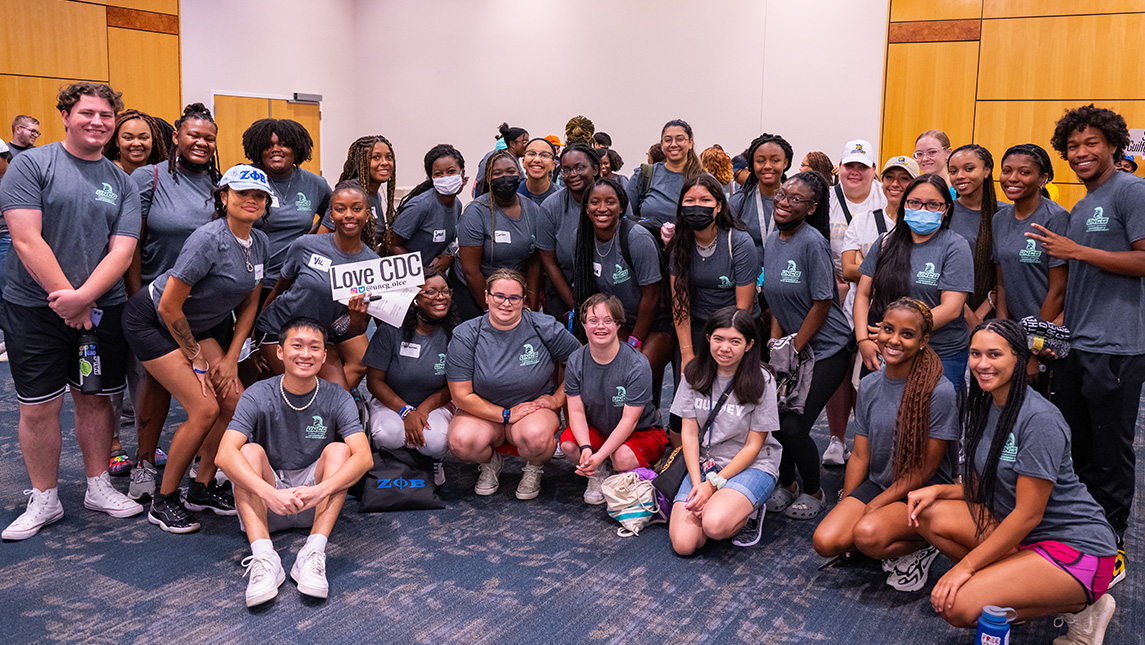 Crowd of students gather around sign reading "Love CDC."