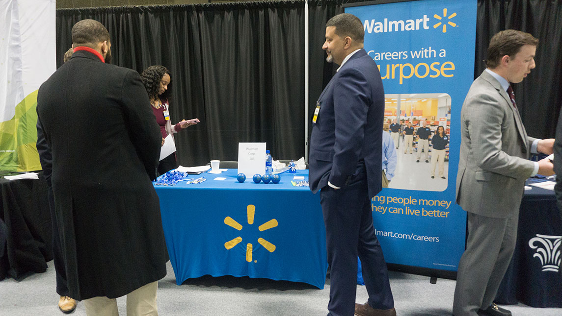 Walmart representative speaking with students at UNCG in-person career fair