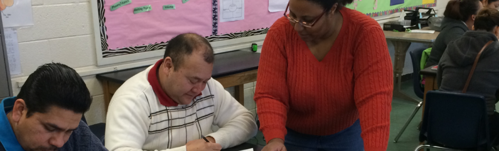 An instructor works with an adult student as part of the Real World English program