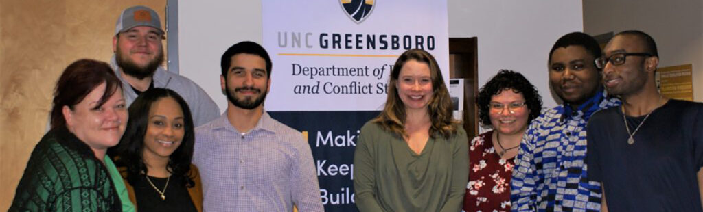 Students from the Peace and Conflict Studies Department stand with Assistant Professor Marcia Hale in the center of the group.