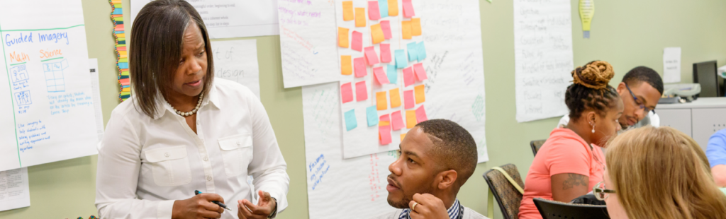 Teacher speaking with ERM students in a classroom setting.