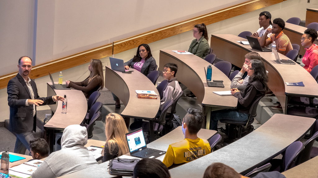 Students listen to the professor during lecture hall class.