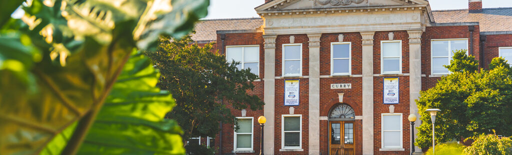 A large brick and stone building on the campus of UNC Greensboro.