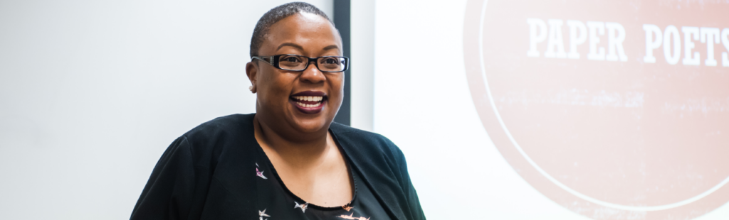 ELC faculty animatedly presenting at the front of a classroom.