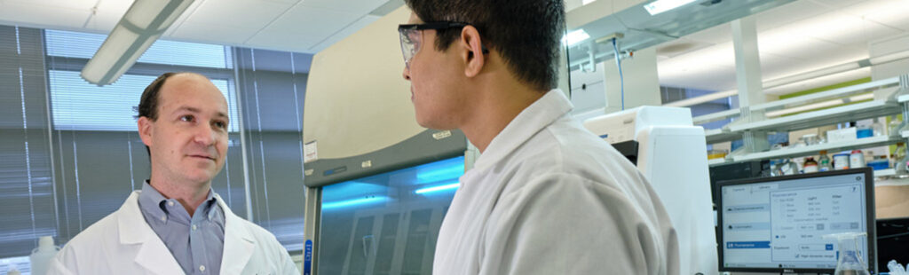 A graduate research student and professsor in the lab at the Joint School of Nanoscience and Nanoengineering