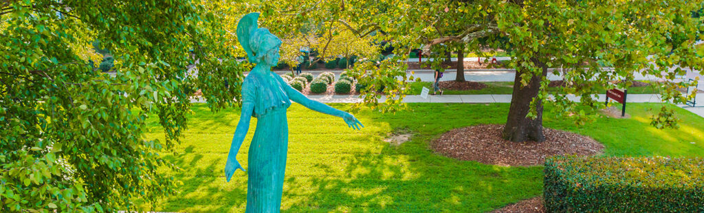 An aerial view of the Statue of Minerva located on UNCG’s campus. There are trees and benches in the background.