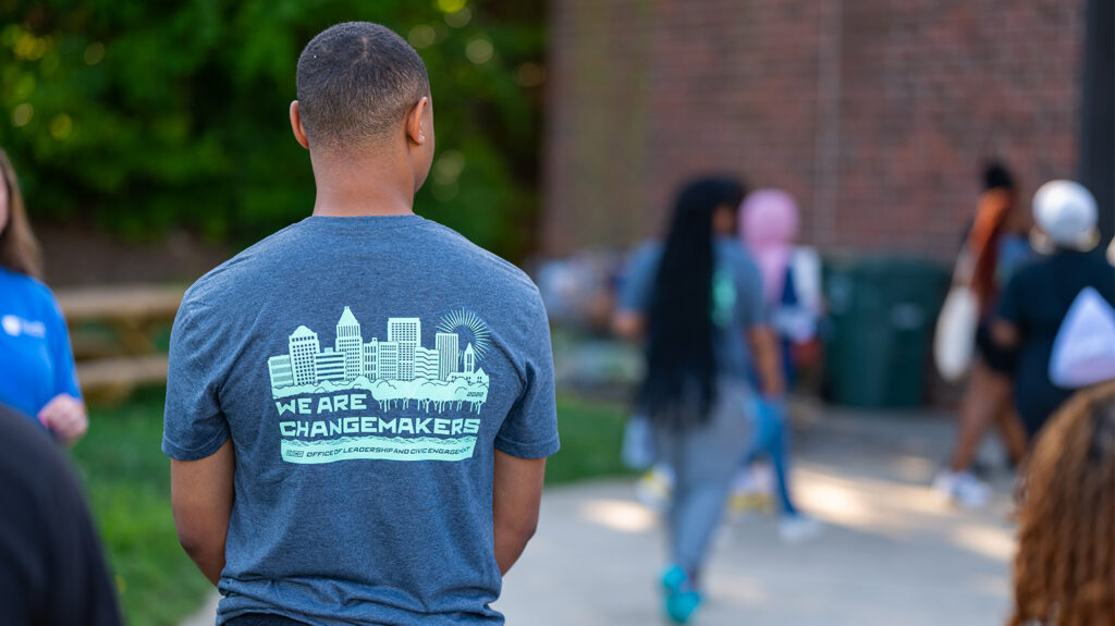 A student wears a t-shirt that reads "We are changemakers" on the back.