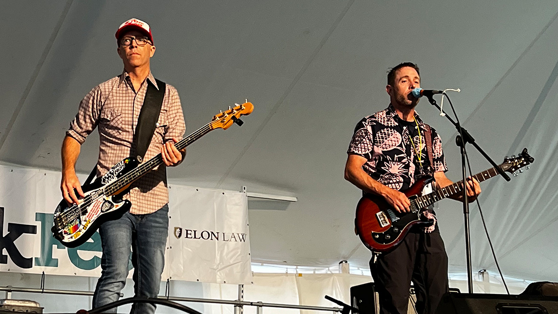 The band Big Bang Boom performs under a tent at the 2022 NC Folk Festival.