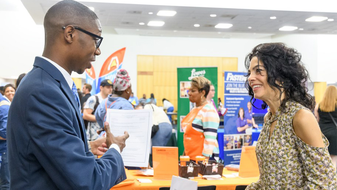 Student introduces himself to a hiring manager at a job fair.