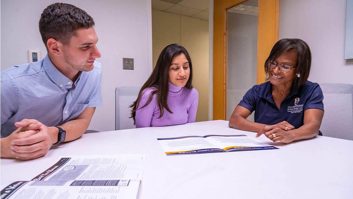 Dr. Nicole Hall assisting two UNCG students