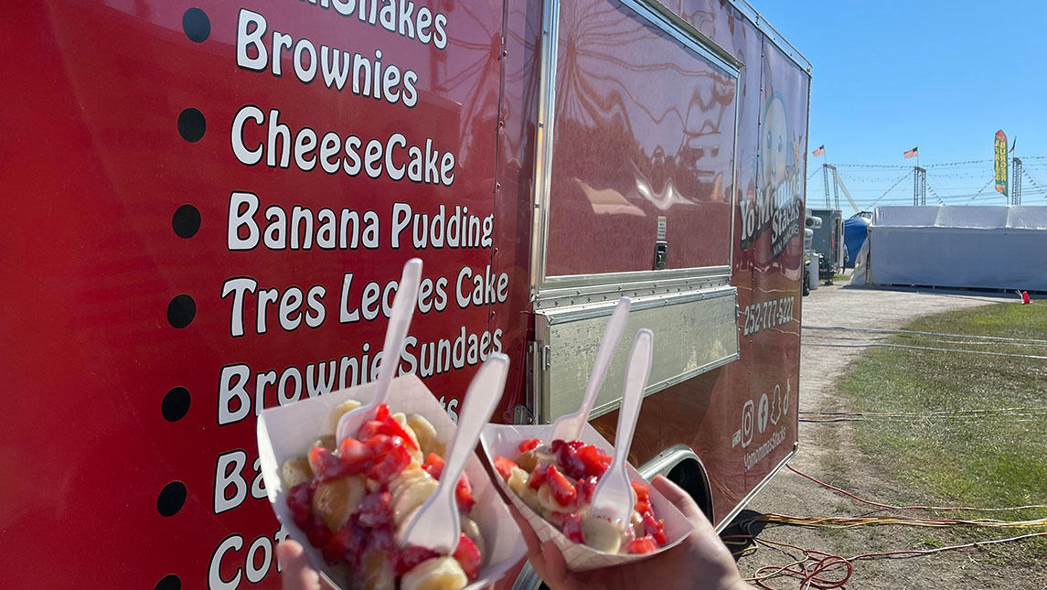Yo Mamma Stacks food truck with two strawberry and banana desserts in front of truck