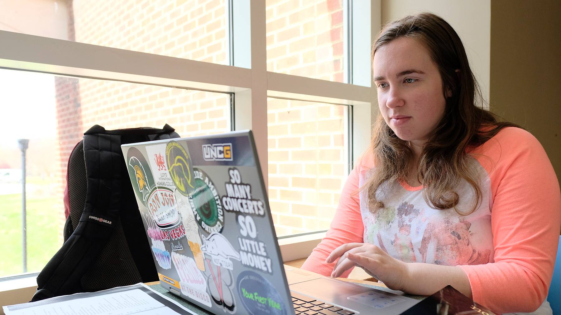 A student types on her laptop while studying at the Jackson Library.