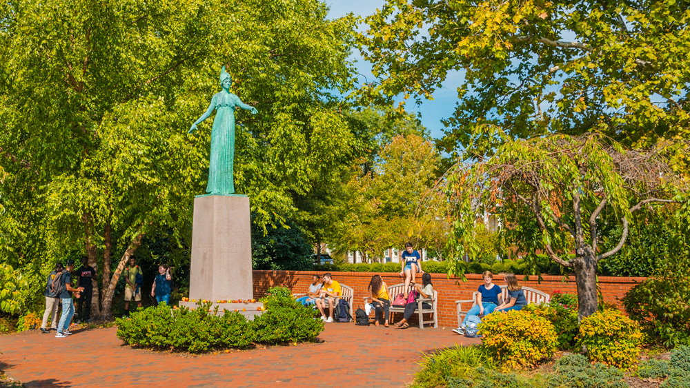 Students enjoying the campus and the Minerva Statue in the summer