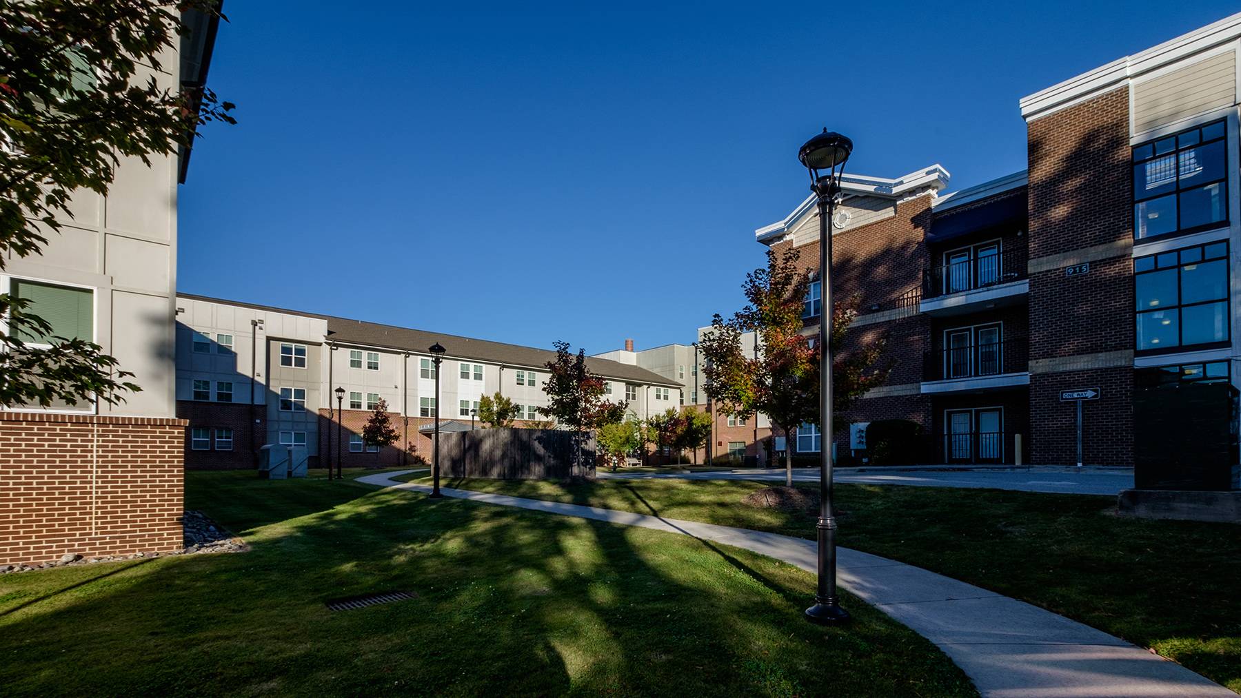 The Lofts on Lee residence hall is pictured with blue skies and late afternoon shadows.
