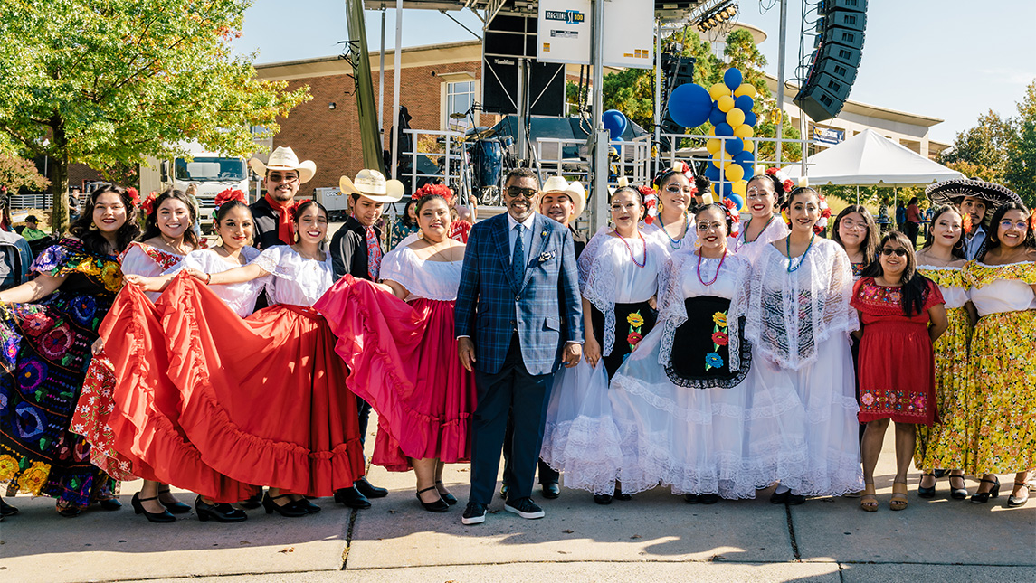 Chancellor Gilliam meets with students in traditional Mexican dress at 2022 Homecoming.