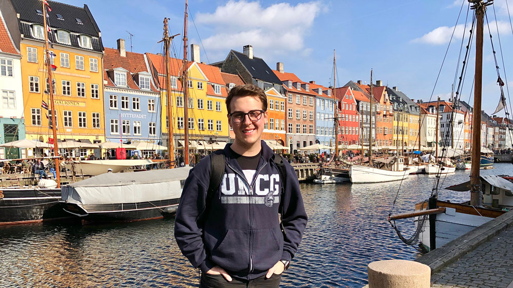 Student wearing a UNCG sweatshirt waterfront in Germany.