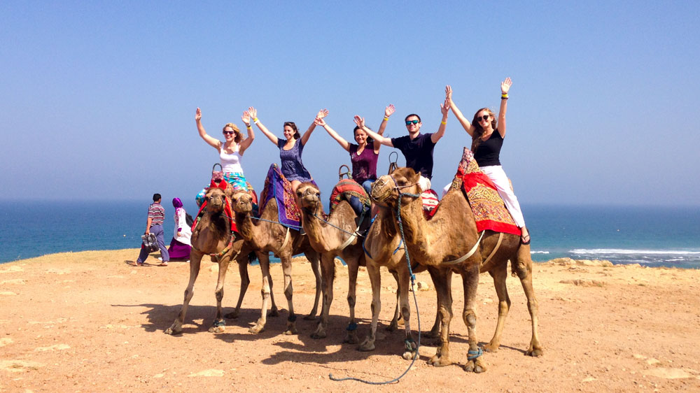 Students on camels on a beach in Spain.