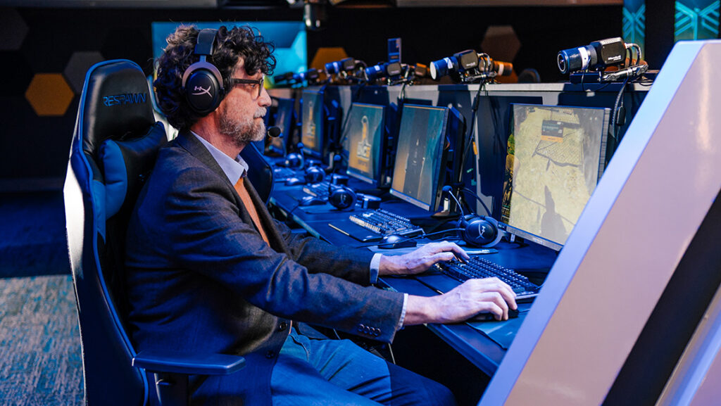 A man plays a video game at a computer.