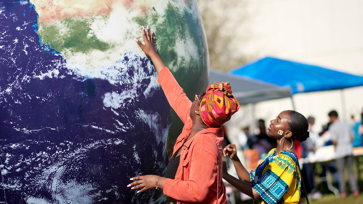 Participants locate an area of the world on a large globe at UNCG’s International Fest.