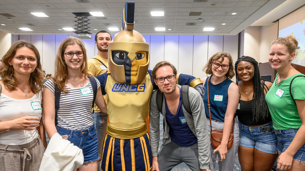 International students posing with Spiro at the International Welcome event.