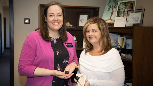 Dr. Jennifer Burkey and Dr. Amy Myers hold up cochlear implants.