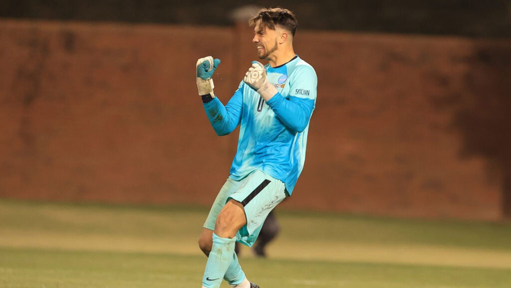 Soccer player celebrates on field during NCAA Division I tournament.