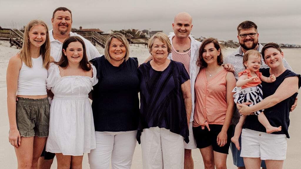 The Penny Family stands on the beach.