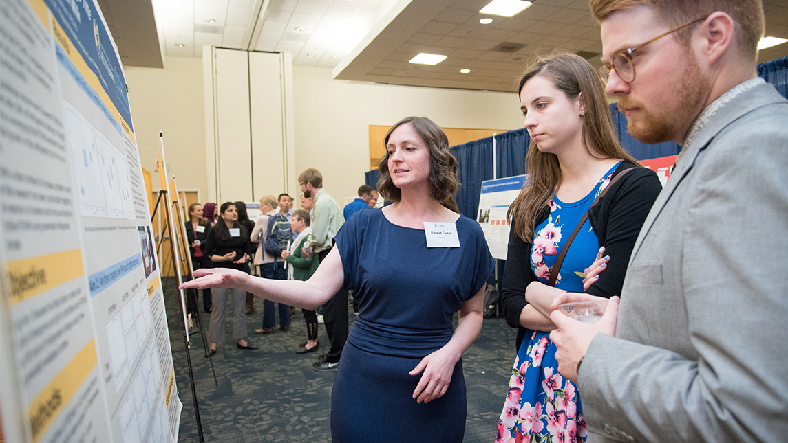 Hannah Carter, a nutrition student, shows off her research board to visitors at the Research Expo.