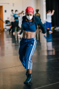 A dance student slides across the studio floor during a masterclass.