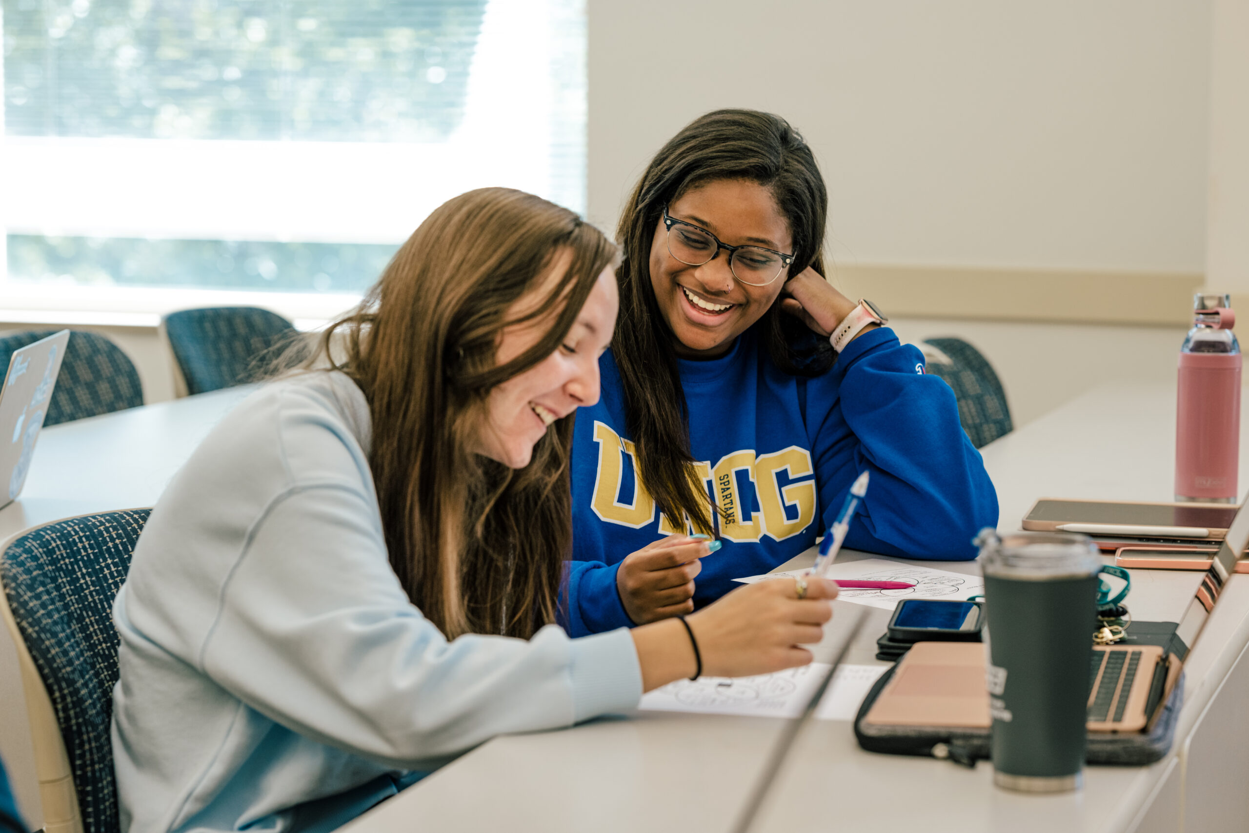 Two smiling students conversing during the First Year Experience 101 course.