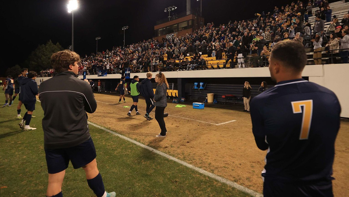 Men's soccer players look out at the packed stadium seats during the 2022 NCAA Division I quarterfinals match against Indiana.