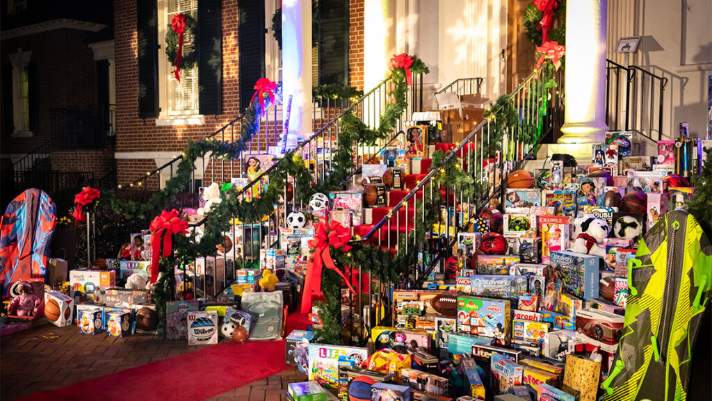Donated toys piled up on a set of decorated stairs of the Alumni House.
