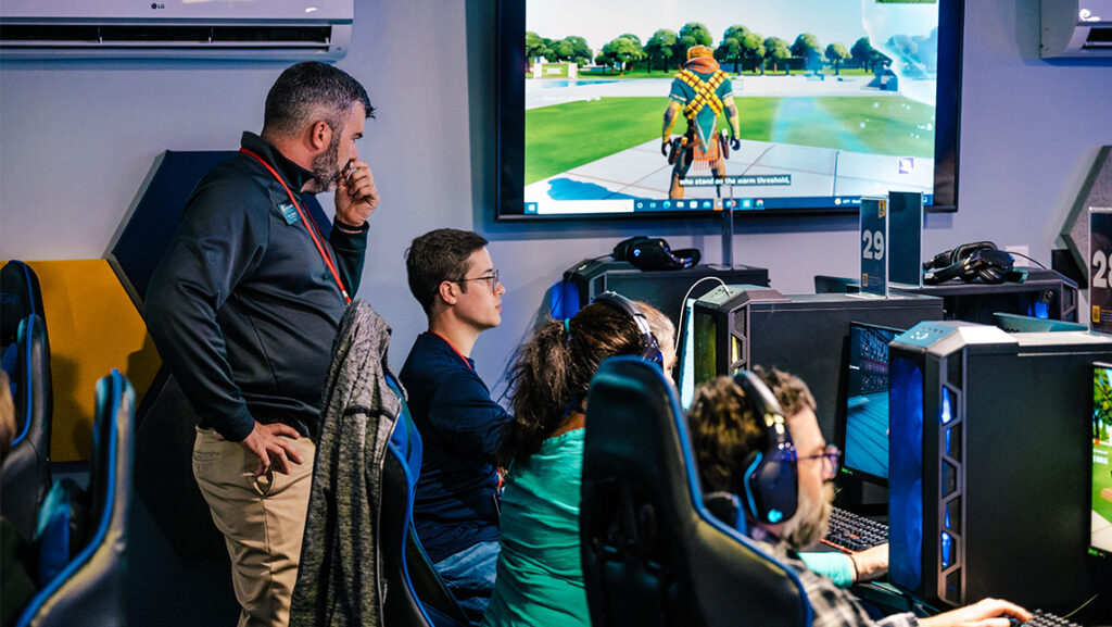 UNCG esports staff works with training participants learning applications of 3D interactive programs used in games like Fortnite.