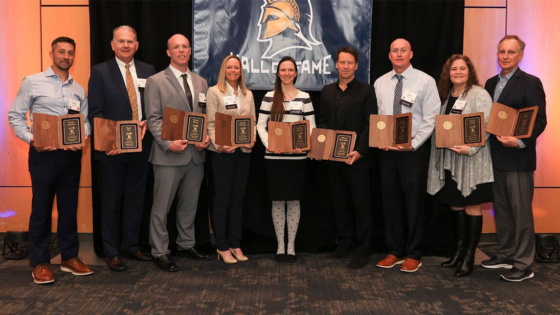 Former UNCG athletes pose after being inducted into the UNCG Athletics Hall of Fame