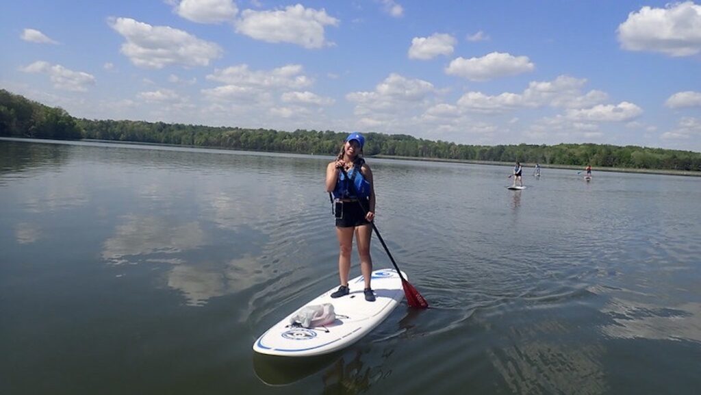 OA team member enjoying paddle boarding on the river.
