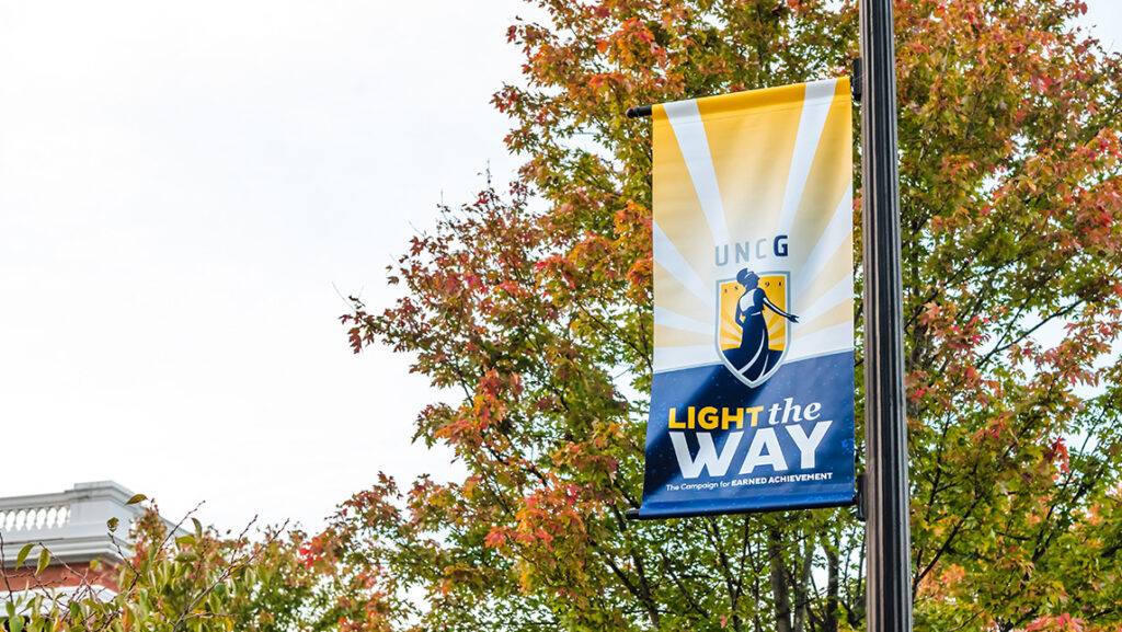 A "Light the Way" banner hangs from a pole.
