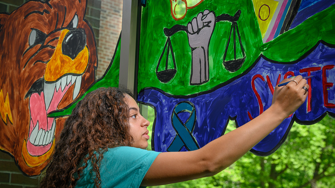Student Jasmine Franco paints a mural at Grogan Hall.