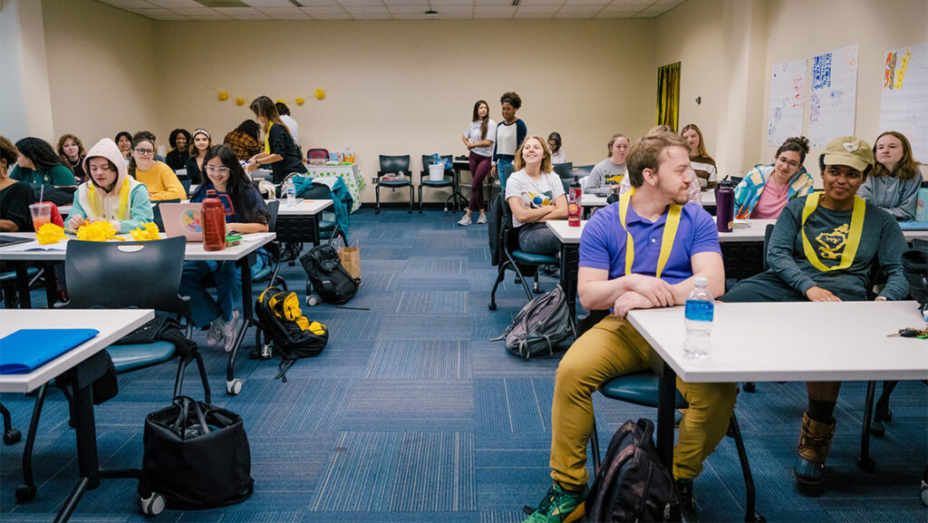 Students converse at their desks during Dr. Rebecca Mathews' CED Master's class.
