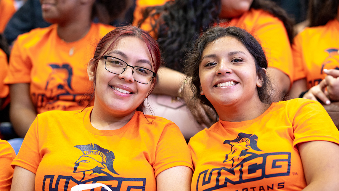 Two new students pose in their UNCG t-shirts.