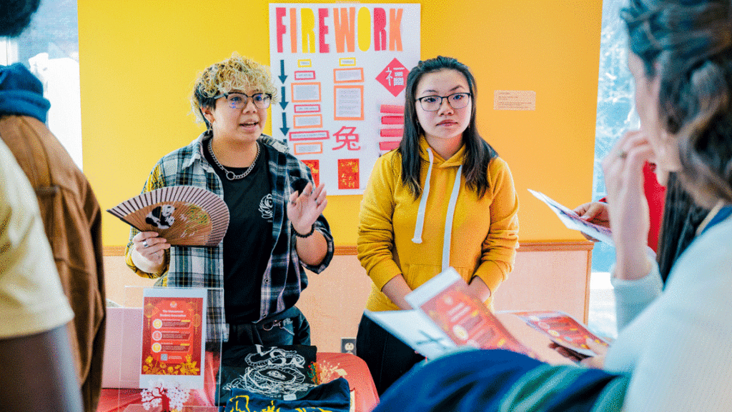 Two students present a poster reading "fireworks"