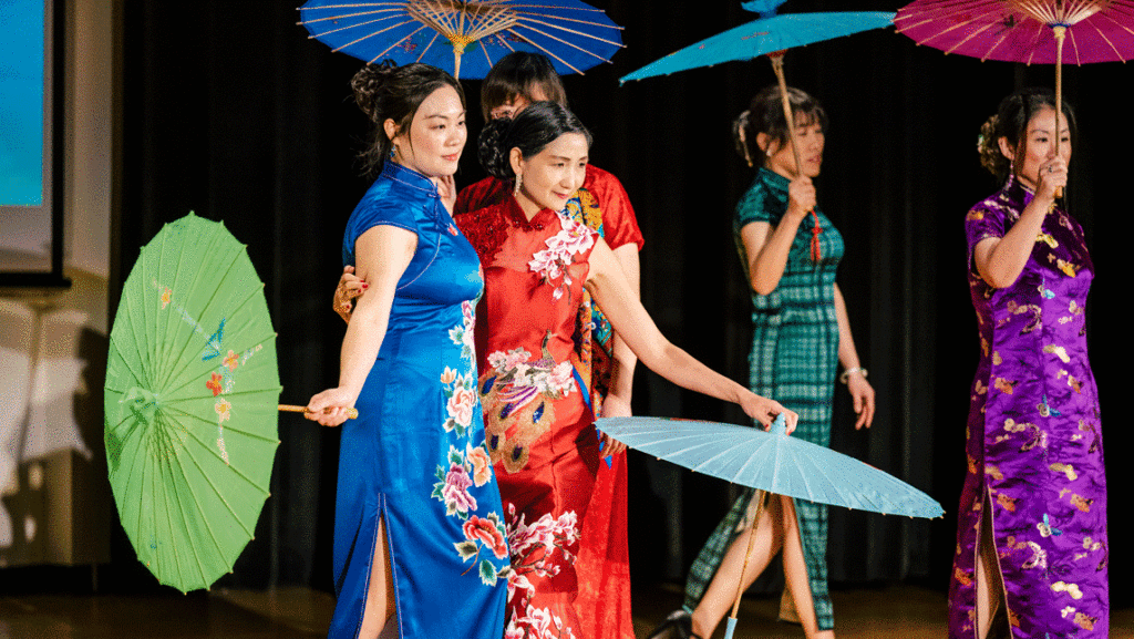 Women dressed in traditional Qipao clothing while dancing on stage