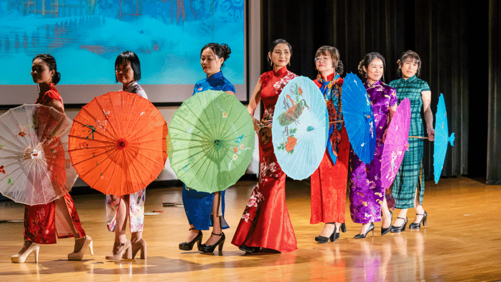 Women in Qipao clothing holds umbrellas on stage