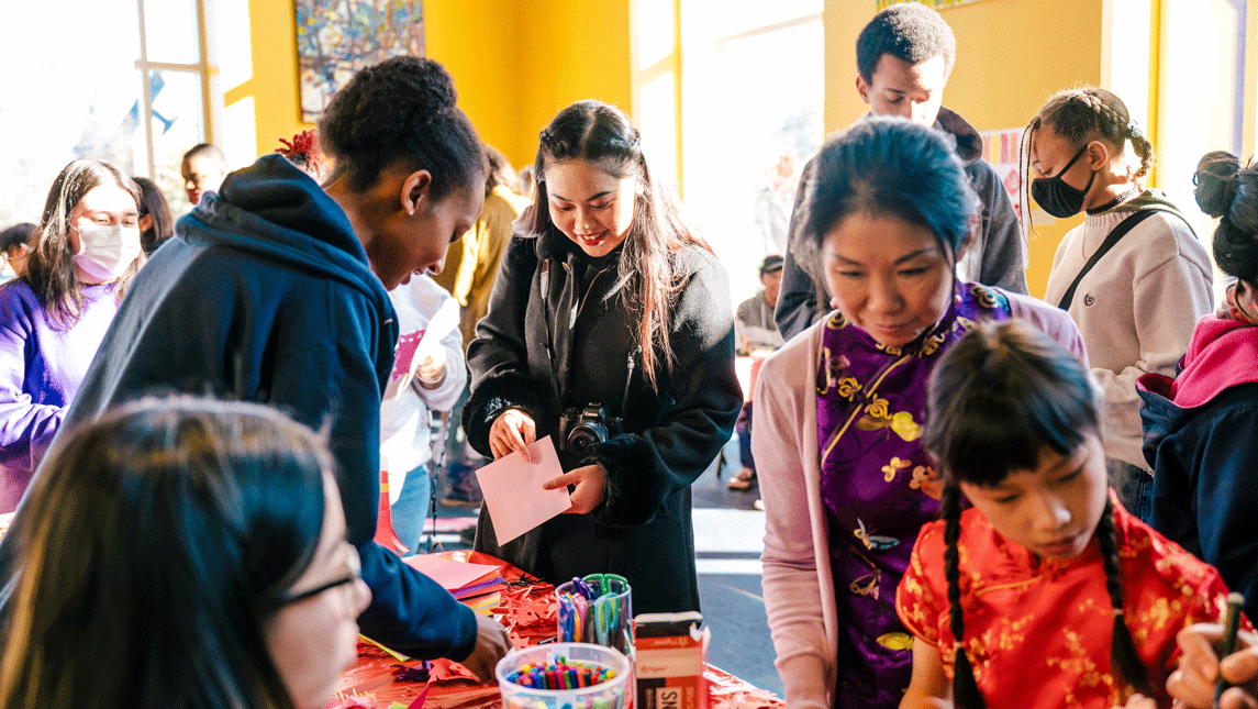 a crowd gathers around a table