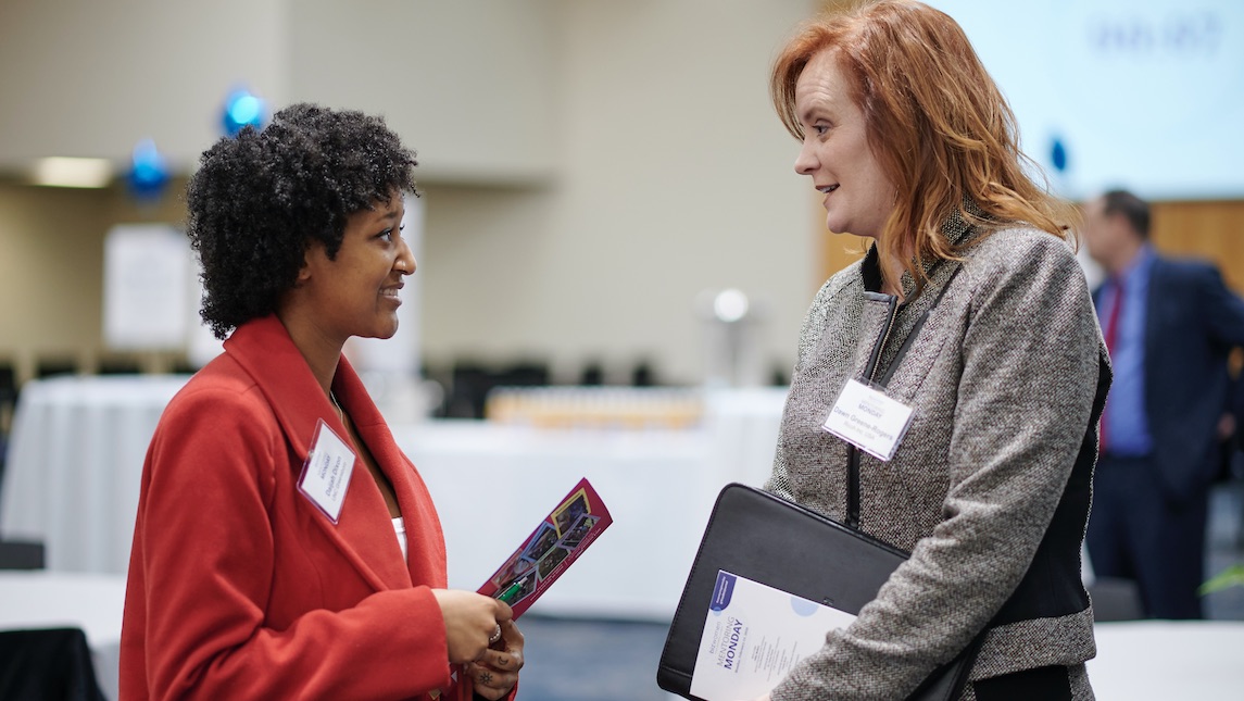 Two women having a discussion at Mentoring Monday conference. 