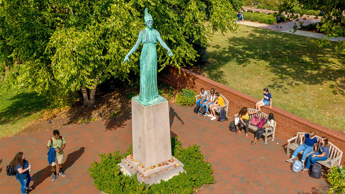 Students congregate on the benches around the Minerva statue.