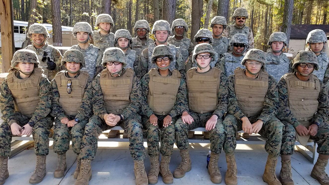 मरीन कॉर्प के सदस्यों का समूह एक साथ बैठता है