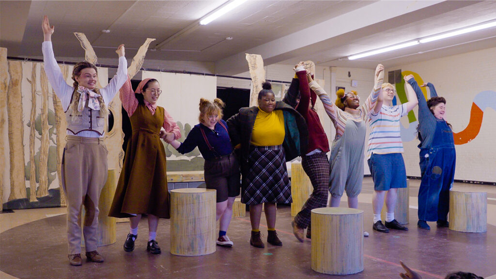 Cast of UNCG's Winnie-the-Pooh raises their arms in the air
