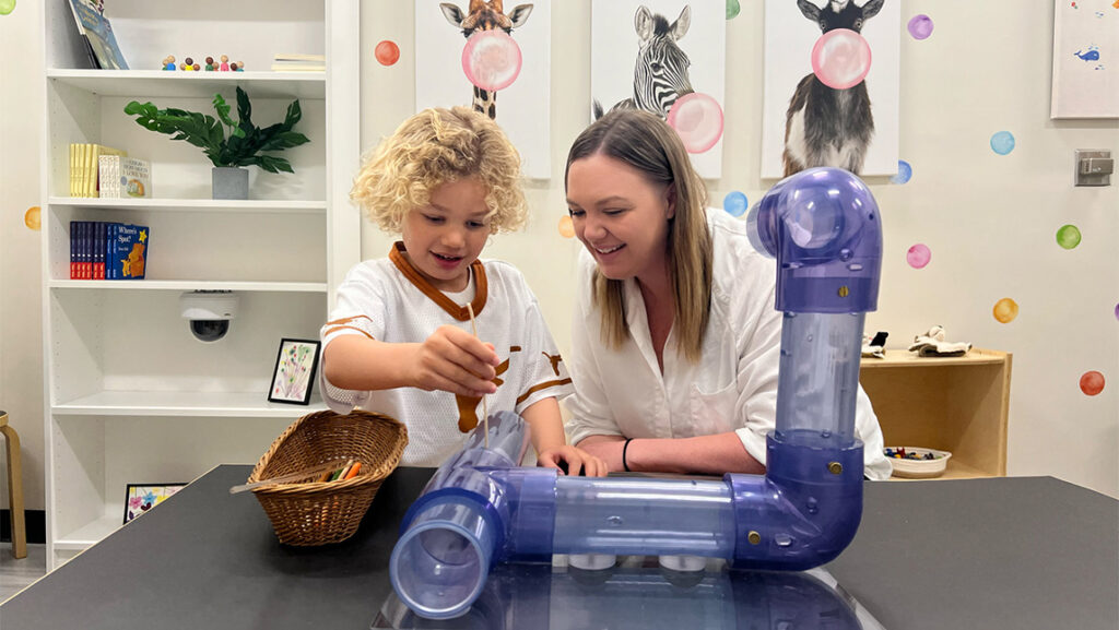 Dr. Nicole Perry, alumna of Human Development and Family Studies, plays with her son in her lab.