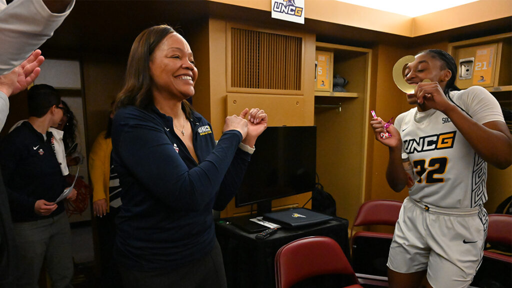 Coach Trina Patterson is congratulated by her basketball players after 100th win in 2023 SoCon tournament against Mercer.