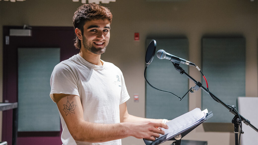 Audio artist Gabriel Coll-Bettencourt standing at the microphone.